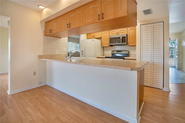 kitchen featuring visible vents, a sink, light countertops, light wood-style floors, and appliances with stainless steel finishes