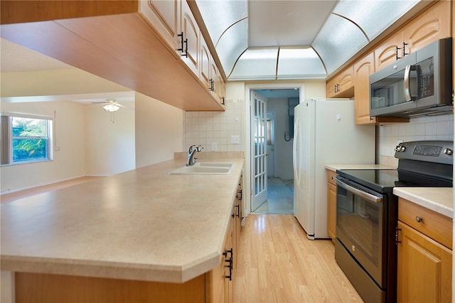 kitchen featuring black range with electric cooktop, tasteful backsplash, light hardwood / wood-style flooring, and sink