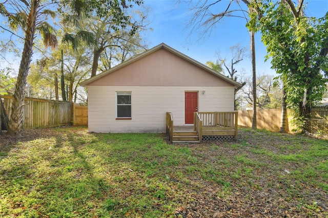 rear view of property with a deck and a yard