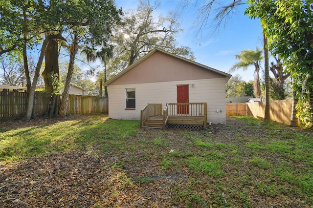 rear view of house featuring a yard and a wooden deck