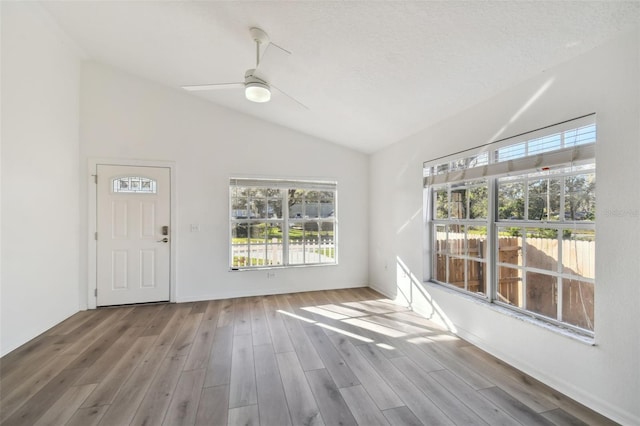 empty room with vaulted ceiling, light hardwood / wood-style flooring, and ceiling fan