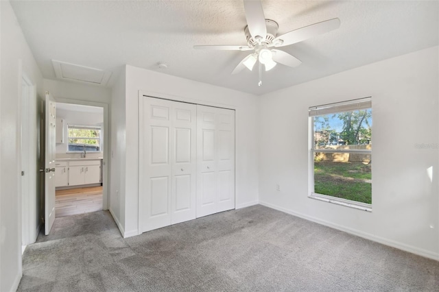 unfurnished bedroom with light colored carpet, ceiling fan, and a closet