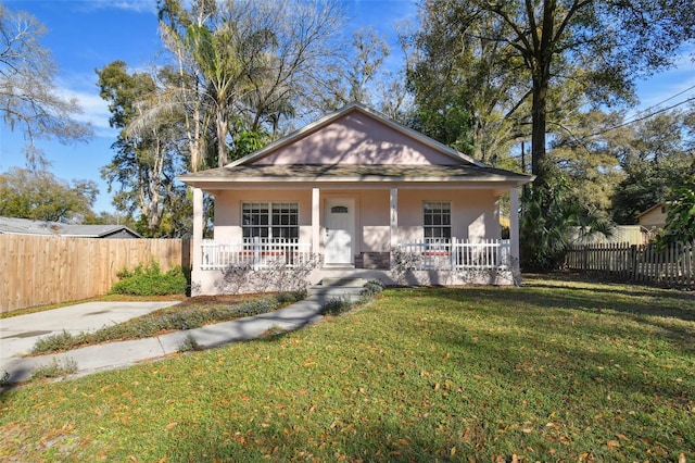 bungalow-style house featuring covered porch and a front yard