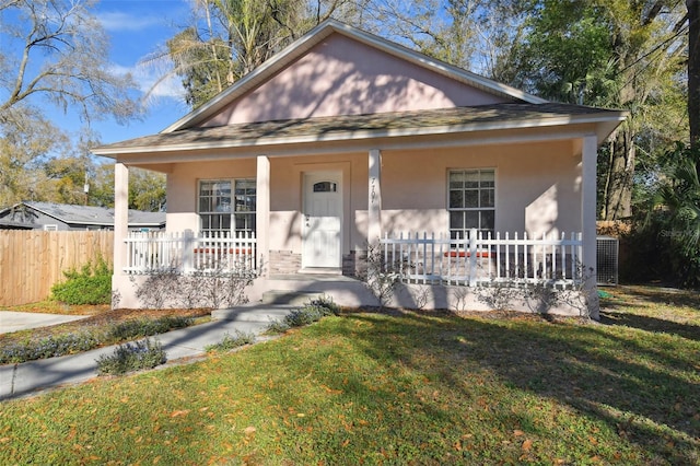 bungalow with covered porch and a front yard