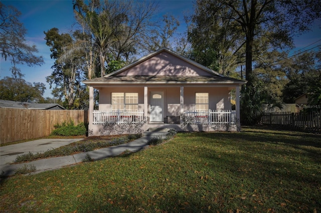 bungalow-style house featuring covered porch and a front lawn