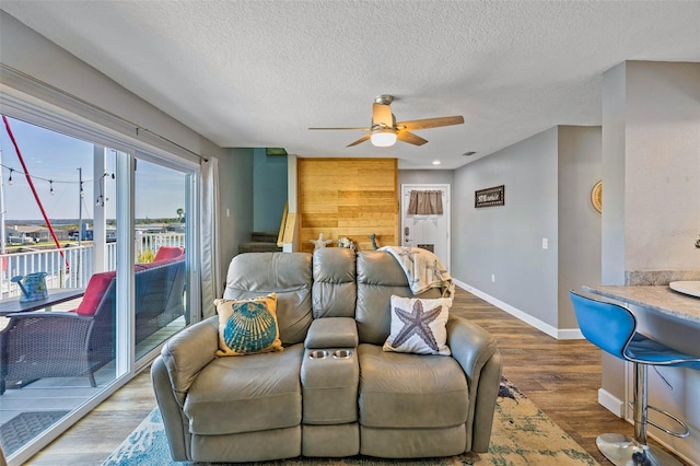 living room with wood-type flooring, a textured ceiling, and ceiling fan