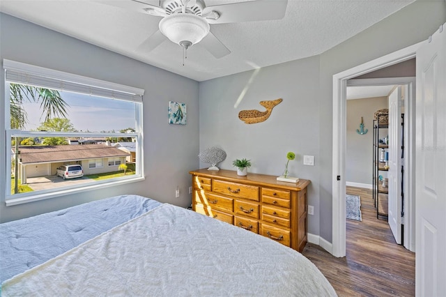 bedroom featuring ceiling fan, wood-type flooring, and a textured ceiling