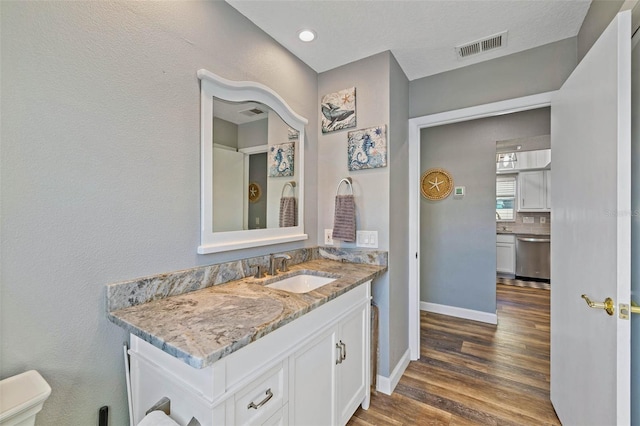 bathroom featuring vanity, backsplash, toilet, a textured ceiling, and wood-type flooring