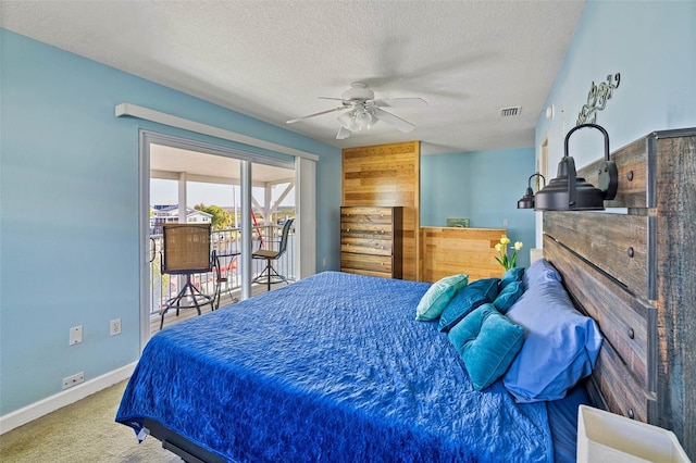 carpeted bedroom featuring ceiling fan and a textured ceiling