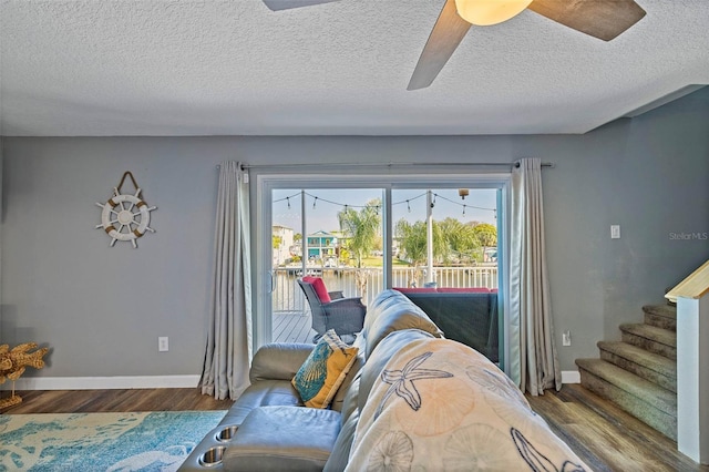 living room featuring ceiling fan, a textured ceiling, and hardwood / wood-style flooring