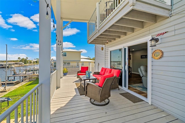 wooden deck with an outdoor living space and a water view