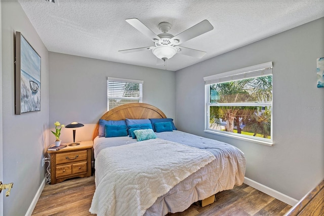 bedroom featuring ceiling fan, a textured ceiling, and hardwood / wood-style flooring