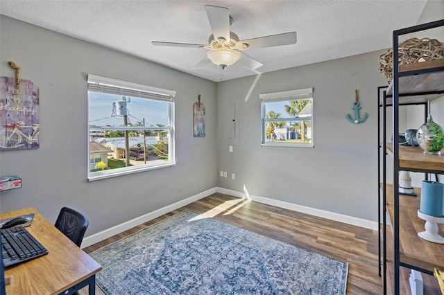 office with dark hardwood / wood-style floors, ceiling fan, and a textured ceiling