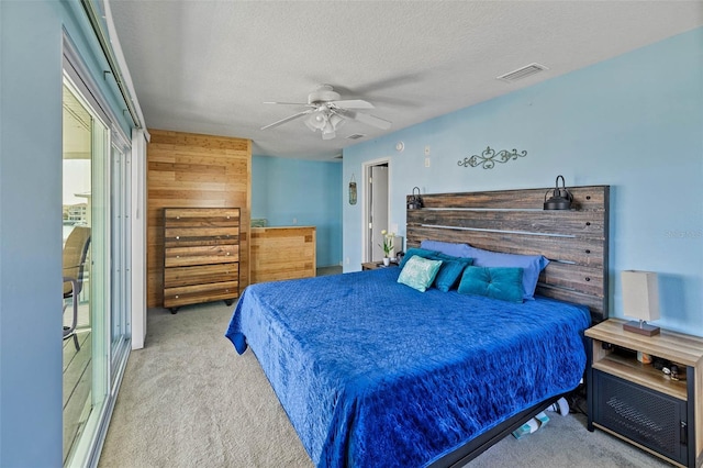 bedroom with ceiling fan, a textured ceiling, and light carpet