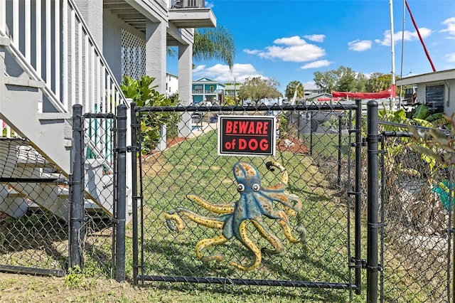 view of gate with a yard