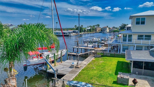 view of dock with a lawn and a water view