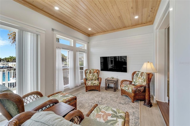 living room with crown molding, light wood-type flooring, and wood ceiling