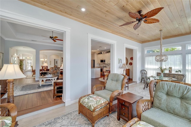 sitting room with light hardwood / wood-style floors, ornamental molding, wooden ceiling, and ceiling fan with notable chandelier