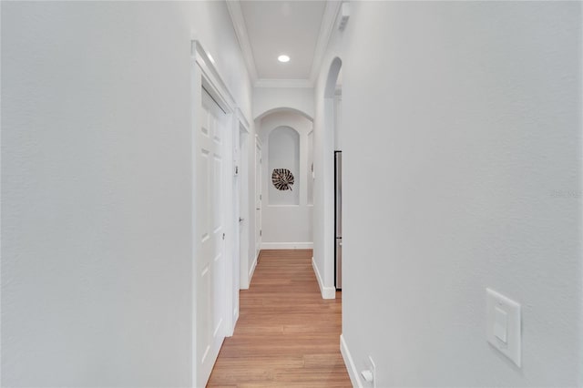 hallway featuring ornamental molding and light wood-type flooring