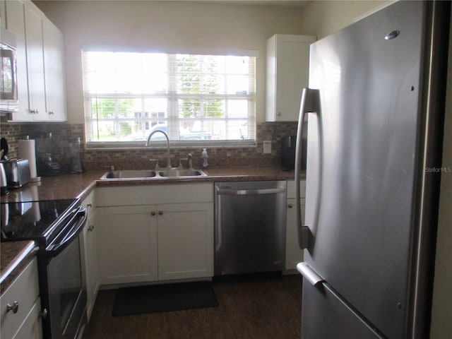 kitchen featuring white cabinets, appliances with stainless steel finishes, tasteful backsplash, and sink