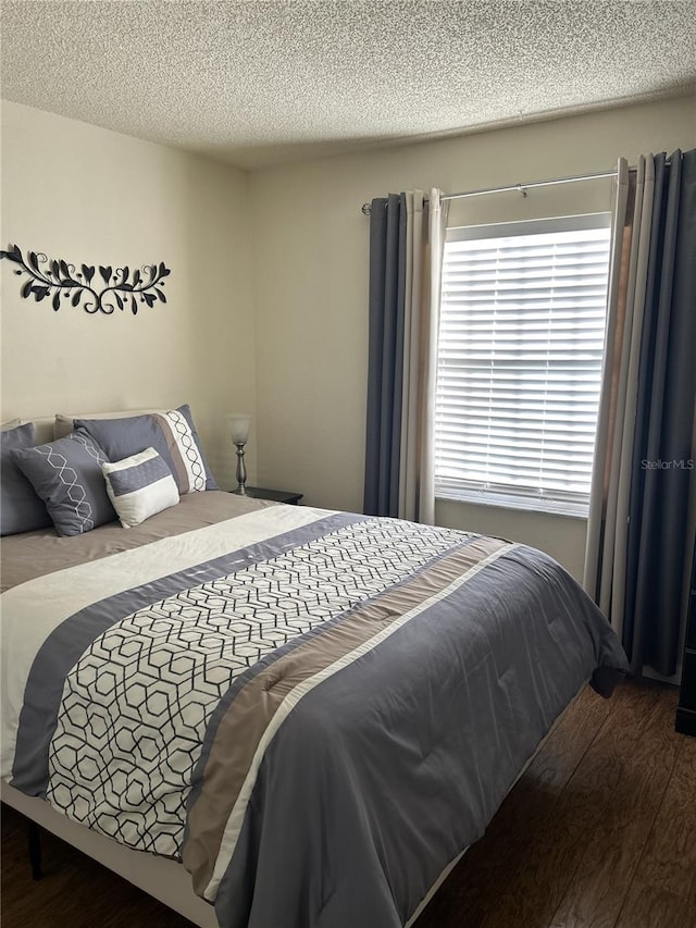 bedroom featuring a textured ceiling and dark wood-type flooring