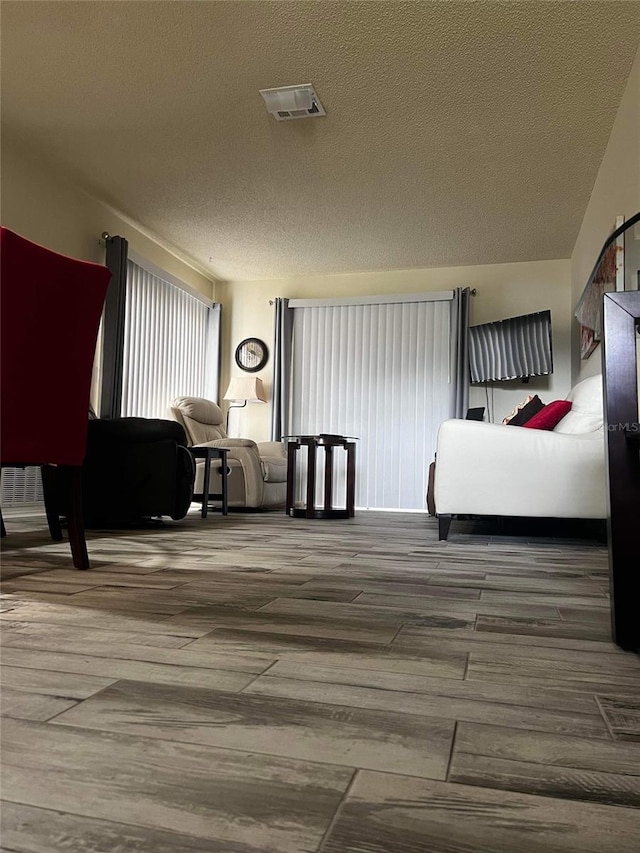 interior space with wood-type flooring and a textured ceiling