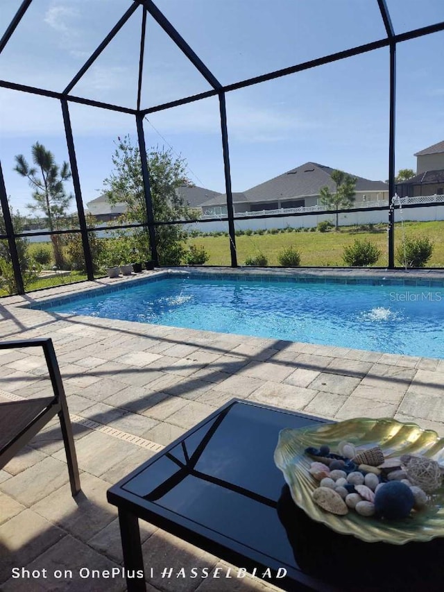 view of swimming pool featuring a patio area and glass enclosure