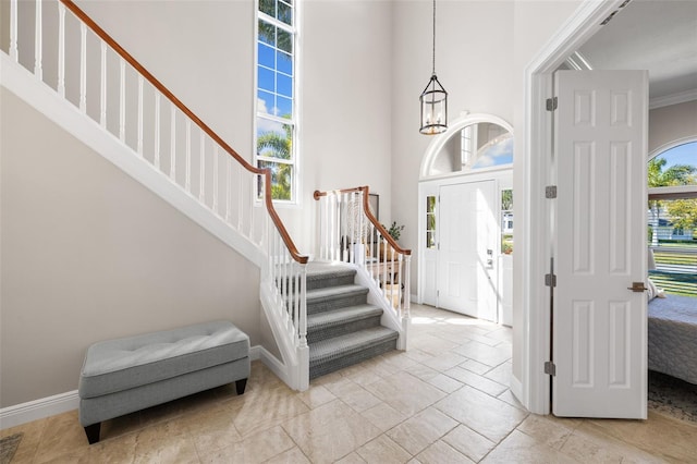 foyer with a notable chandelier and crown molding