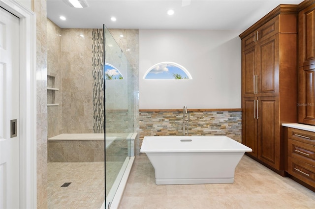 bathroom featuring plus walk in shower and tile walls