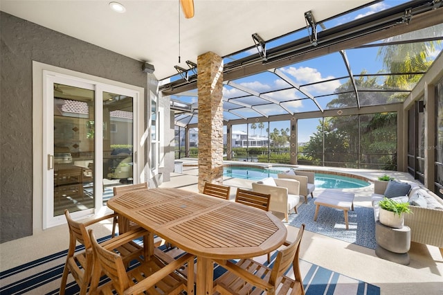 view of patio featuring ceiling fan and a lanai