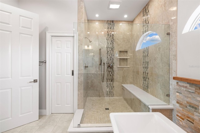 bathroom with a tile shower and tile patterned floors