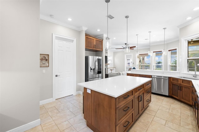 kitchen featuring ceiling fan, sink, stainless steel appliances, pendant lighting, and a kitchen island