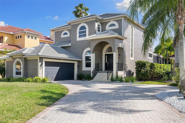 mediterranean / spanish-style house featuring a garage and a front lawn