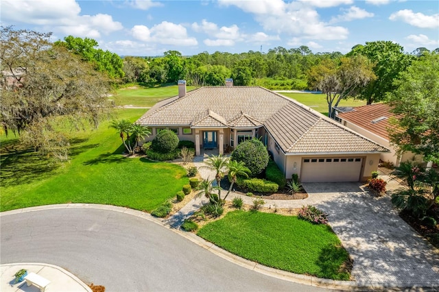 mediterranean / spanish house featuring a front lawn and a garage