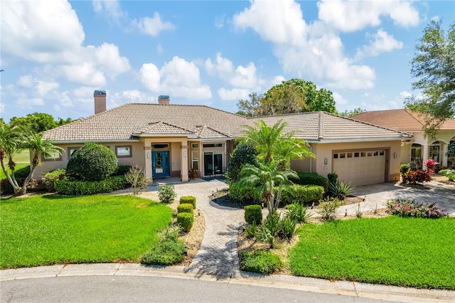 mediterranean / spanish-style home featuring a front yard and a garage