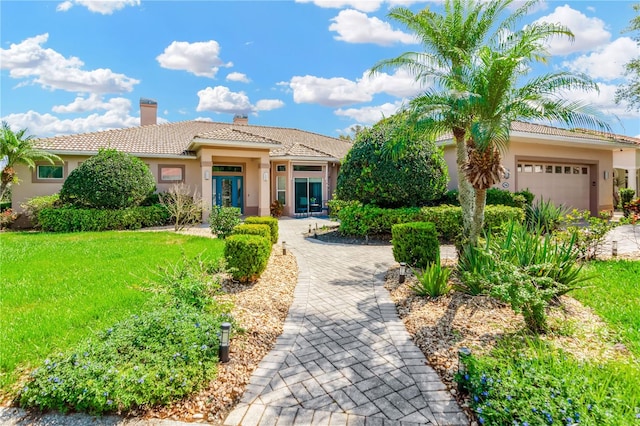 mediterranean / spanish-style house with a front yard and a garage