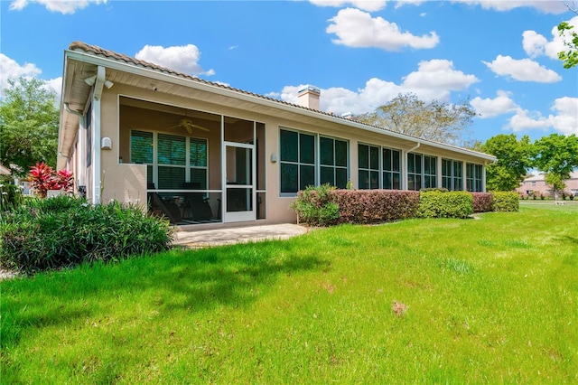 back of property with a lawn, ceiling fan, and a patio