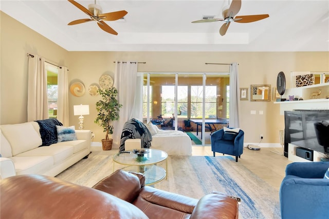 living room featuring ceiling fan, light tile floors, and a wealth of natural light