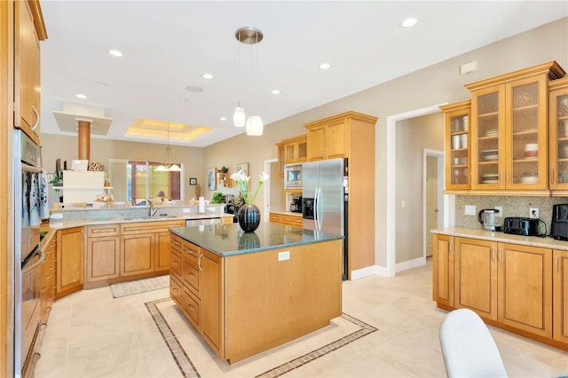 kitchen featuring hanging light fixtures, backsplash, light tile floors, dark stone counters, and a kitchen island