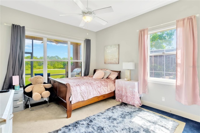 carpeted bedroom featuring ceiling fan and multiple windows