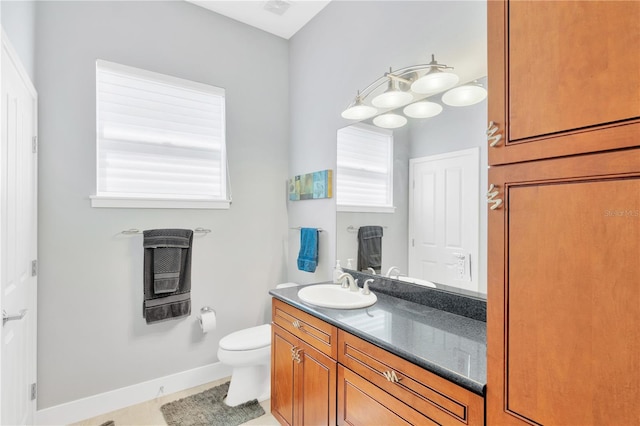 bathroom with toilet, tile floors, and vanity