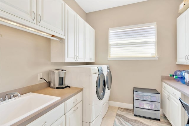 laundry room with sink, cabinets, washing machine and clothes dryer, and light tile flooring