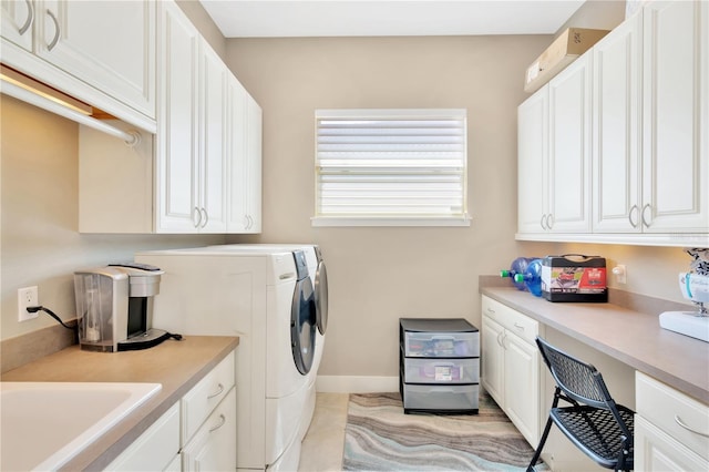 washroom featuring cabinets, light tile floors, sink, and washer and clothes dryer