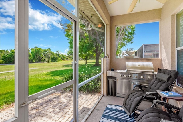 sunroom / solarium featuring ceiling fan