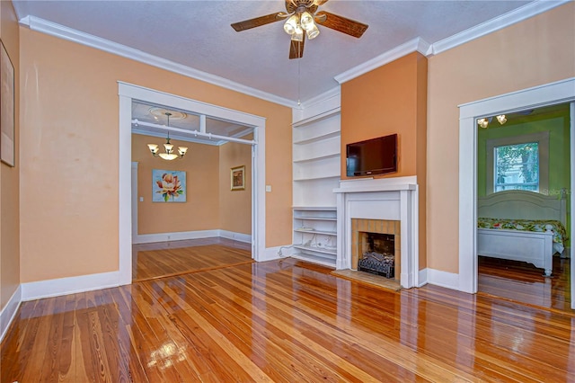 unfurnished living room with a fireplace, a textured ceiling, wood-type flooring, crown molding, and built in shelves