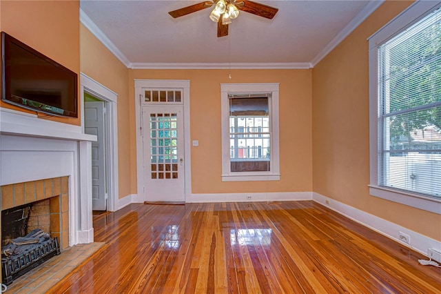 unfurnished living room with light wood-type flooring, a tile fireplace, and plenty of natural light