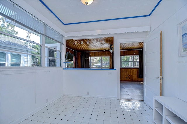 spare room featuring wood ceiling, wooden walls, ceiling fan, and a wealth of natural light