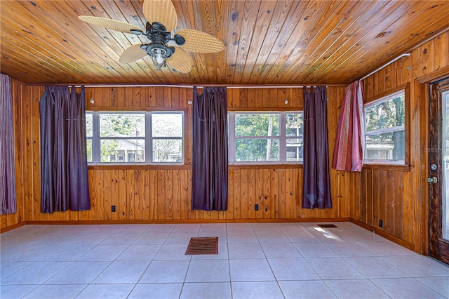 tiled spare room with wooden walls and plenty of natural light