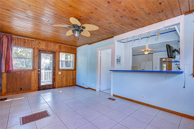 interior space featuring wooden ceiling, wooden walls, and ceiling fan