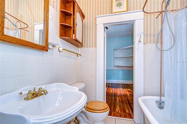 full bathroom with shower / tub combo, tile walls, hardwood / wood-style floors, toilet, and sink